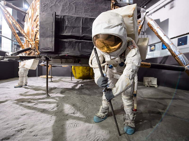 A recreation of the moon landing. A mannequin dressed like an astronaut stands in front of a model of the lunar lander